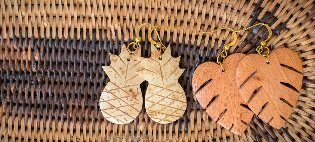 Two pair of earrings handcarved in the Philippines from coconut shell, photographed on a rattan tray.