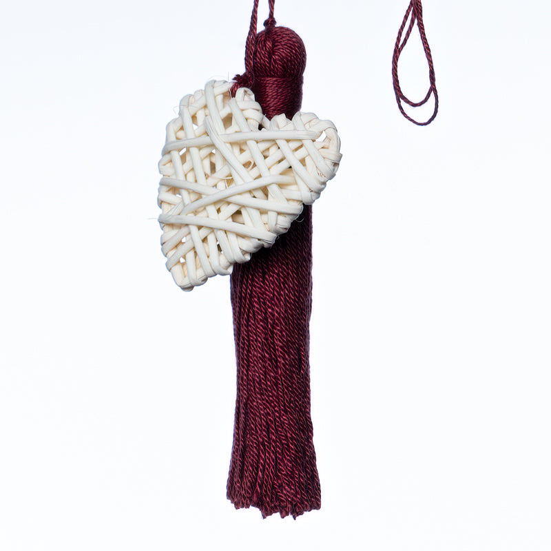 Handbag charm accessory, hand made in Philippines in shape of a small heart woven from natural rattan with a yarn tassel in burgundy.