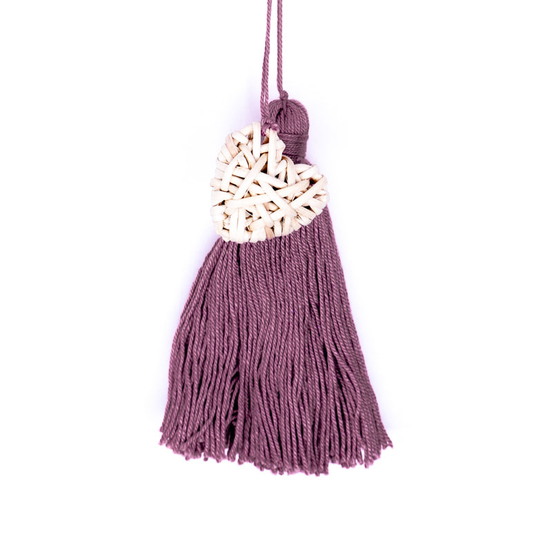 Handbag charm accessory, hand made in Philippines in shape of a small heart woven from natural rattan with a yarn tassel in mauve.