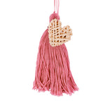 Handbag charm accessory, hand made in Philippines in shape of a small heart woven from natural rattan with a yarn tassel in pink.