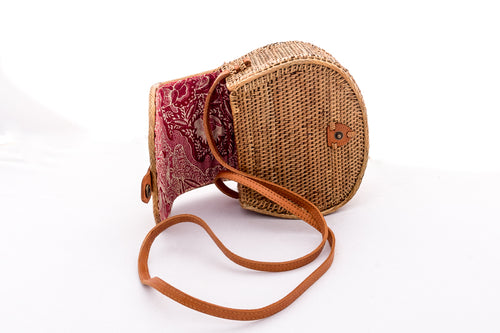 Handwoven handbag in natural rattan from Bali Indonesia, showing colorful, patterned cotton lining.