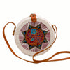 Round white rattan handbag hand woven in Bali, with hand painted insert showing bird & flower in red, yellow, blue & green inside an 8-pointed star, along with leather strap & brass clasp.
