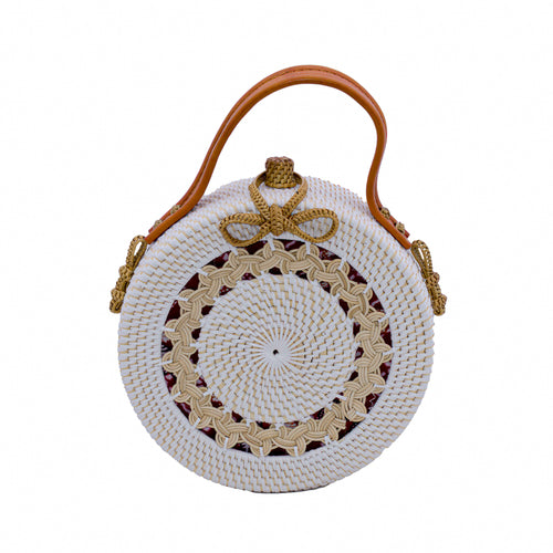 Round white rattan bag handwoven in Bali, showing tight rattan weaving, braided design & braided rattan ribbon closure. Use leather handle to carry as a handbag, or as shoulder bag with removable leather shoulder strap.