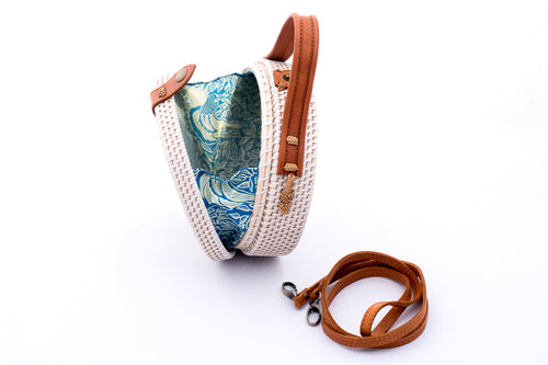 White rattan handbag hand woven in Bali Indonesia showing leather handle, removable leather strap & colorful, patterned lining.  